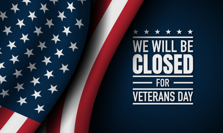 An American flag on the left and text on a dark blue background on the right. The text reads: 'WE WILL BE CLOSED FOR VETERANS DAY'.